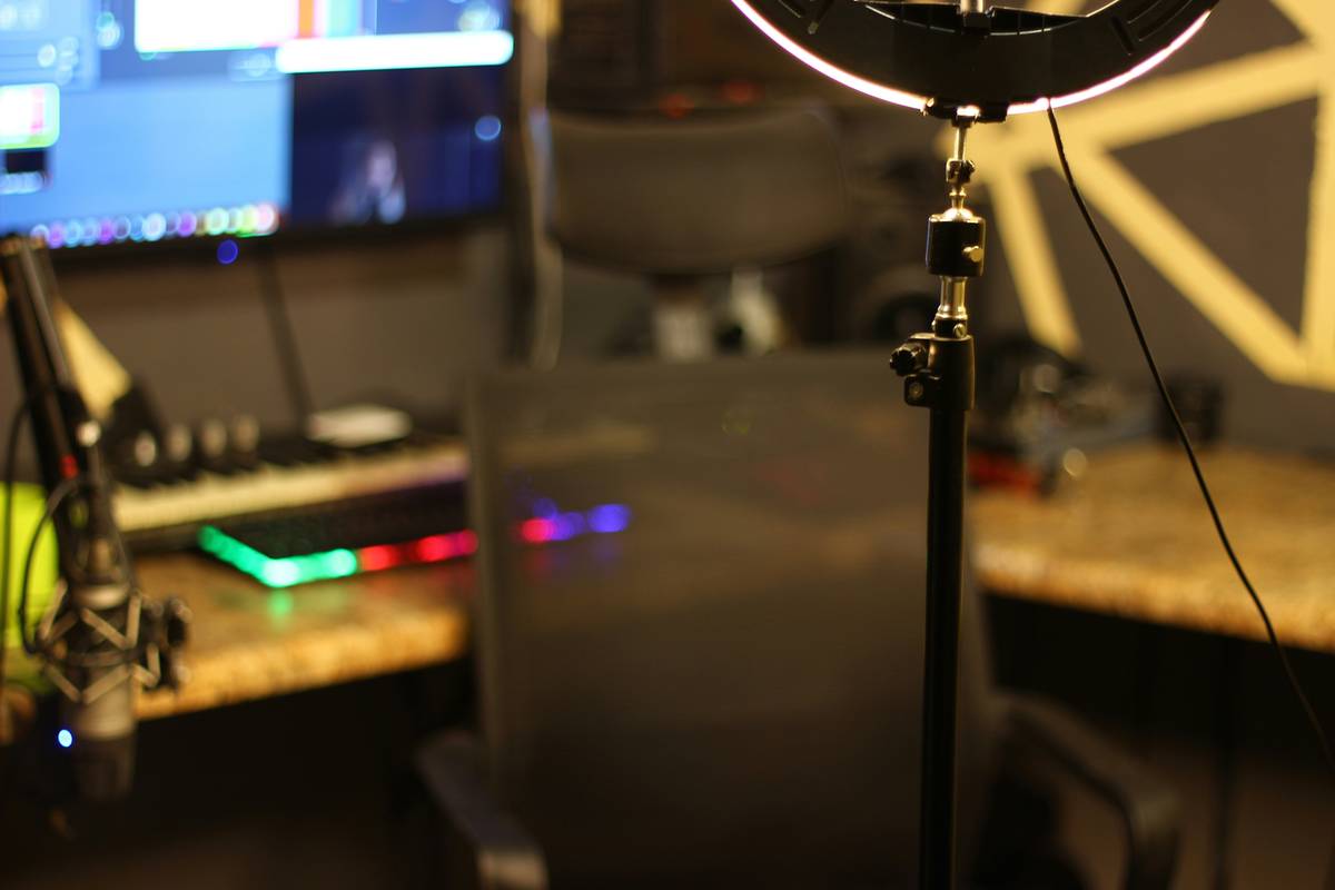 Close-up of a neatly organized streaming desk featuring two monitors, keyboard, mouse, and a boom arm microphone.